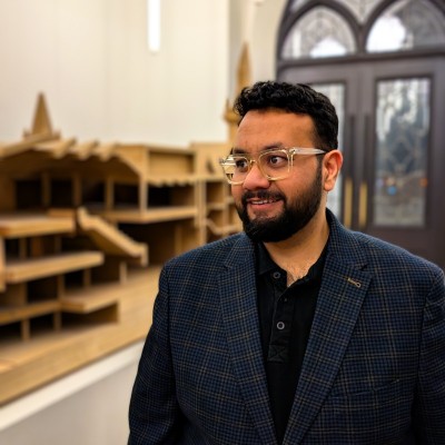 Osama Khan standing beside architectural models